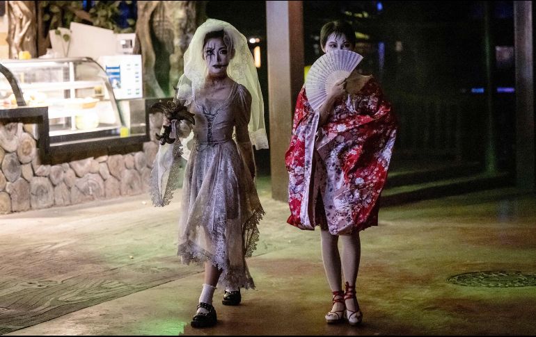 Personas disfrazadas caminan por las calle durante una celebración antes en Guangzhou, China. AFP