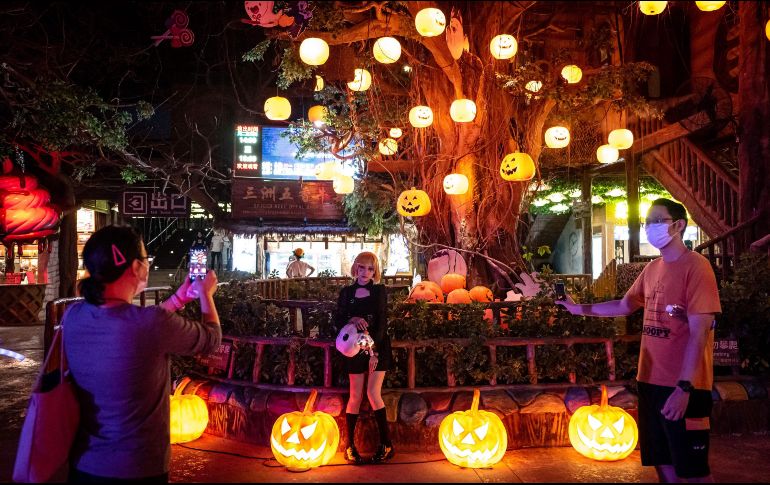 Personas disfrazadas caminan por las calle durante una celebración antes en Guangzhou, China. AFP