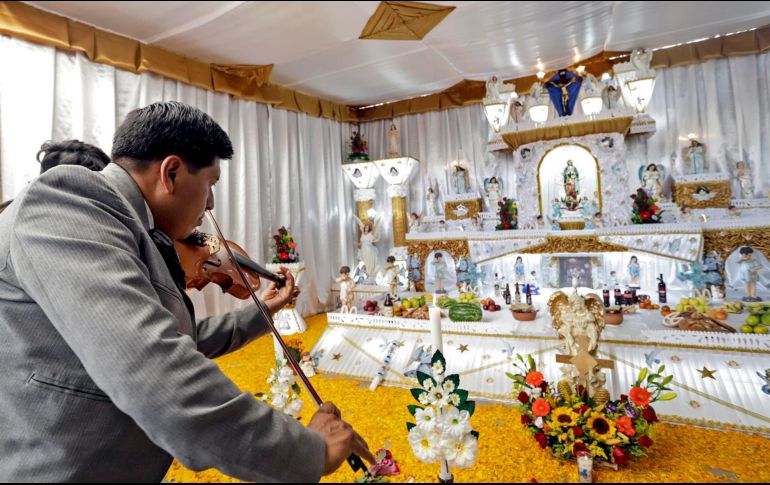 Los niveles son amplios y en ellos se coloca fruta, pan, comidas y bebidas que le gustaba al difunto, además de imágenes de niños o ángeles que custodian el altar, un espejo, agua, sal, flores y veladoras. EFE / H. Ríos