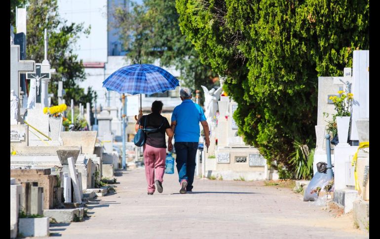 Poco a poco las lápidas viejas y llenas de polvo se vistieron de flores, adornos, botellas, comida y mucha alegría por parte de los visitantes. EL INFORMADOR/A. Navarro