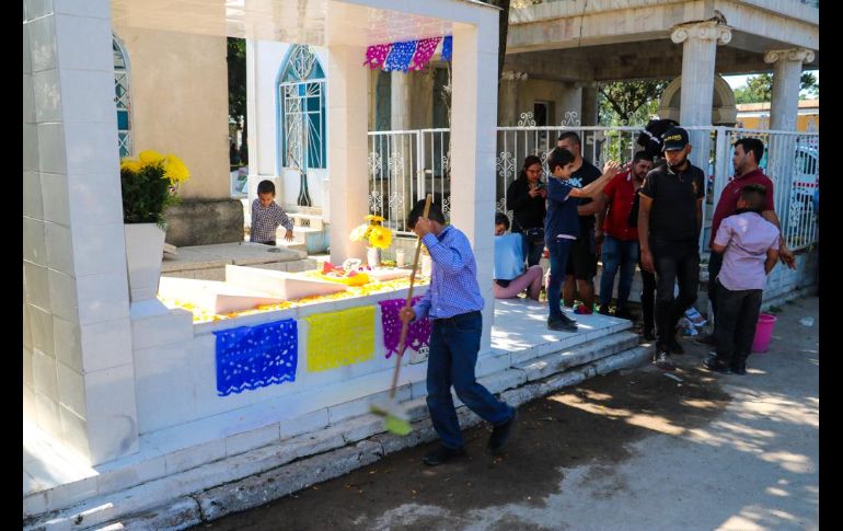 Poco a poco las lápidas viejas y llenas de polvo se vistieron de flores, adornos, botellas, comida y mucha alegría por parte de los visitantes. EL INFORMADOR/A. Navarro