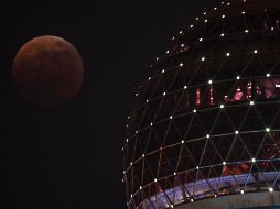 La Luna de sangre se ve desde el paseo del Bund durante un eclipse total en Shanghái, China, este 8 de noviembre de 2022. AFP / H. Retamal