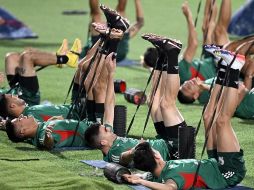 Con el grupo de 'sparrings' en un lado del terreno, en el otro los jugadores del Tri completaron ejercicios de calentamiento con el balón y estiramientos. AFP / A. Estrella