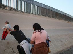Una pareja con sus hijos corre sobre el Río Bravo, en el punto fronterizo del Paso del Norte, en Ciudad Juárez, con el fin de ingresar a territorio estadounidense. EFE/ARCHIVO
