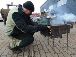 Un trabajador prueba el funcionamiento de estufas de metal hechas a mano destinadas a militares ucranianos y desplazados internos del este del país, en una fábrica en los suburbios de Lviv. EFE/M. Tys
