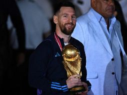 Lionel Messi fue el primero en bajar del avión para mostrar la copa mundial a los aficionados que aguardaban en el aeropuerto. AFP/L. Robayo