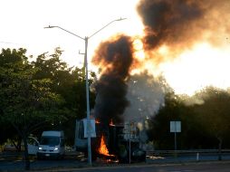 Fotografía de un vehículo de carga calcinado tras los enfrentamientos de fuerzas federales con grupos armados hoy, en Culiacán, Sinaloa. EFE / J. C. Cruz