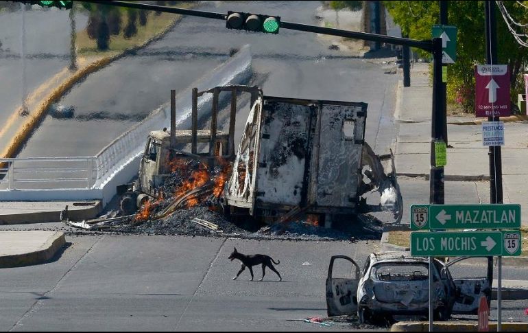 En varios puntos de Culiacán, los restos de camiones y automóviles incendiados dificultaban el tránsito. EFE/J. Cruz