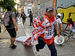 Manifestantes huyen de la policía, durante la jornada de protestas que ayer inundaron la capital peruana. AFP
