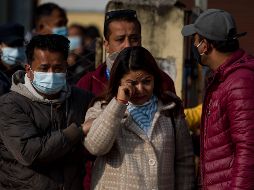 Familiares de las víctimas de un accidente aéreo de Yeti Airlines esperan a que los restos de sus seres queridos sean cargados en camiones. XINHUA/S. Shrestha