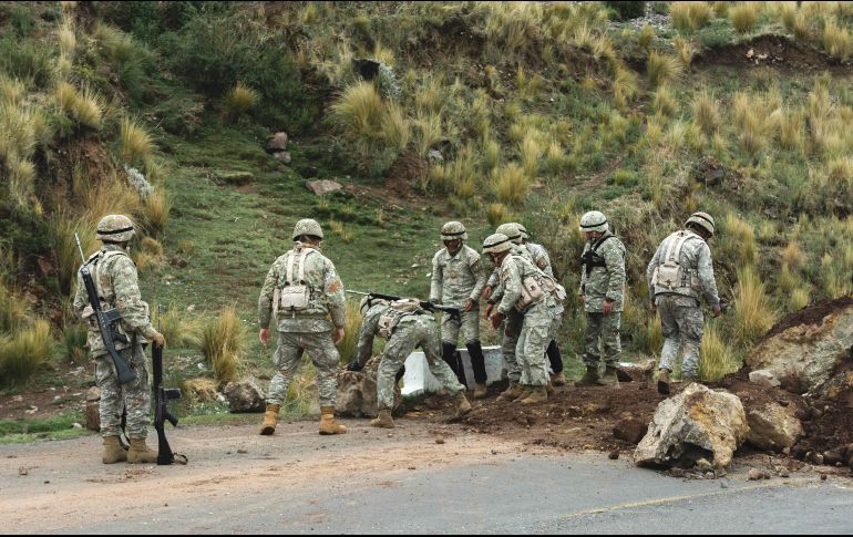 Un grupo de miembros de las fuerzas militares trabajan en el desbloqueo de una vía que une la localidad de Laraqueri con la ciudad de Puno. EFE