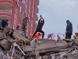 En medio de las bajas temperaturas, rescatistas y civiles tratan de ayudar a las personas atrapadas. En la foto, un habitante de la ciudad de Adana, en Turquía, busca abrirse paso entre los escombros con un marro. AP
