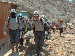 Rescatistas recuperan cuerpos de las montañas de lodo. AFP