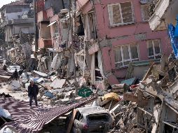 Una persona camina entre edificios colapsados en medio de un panorama desolador en Hatay, Turquía. AP/H. Malla