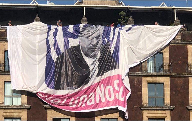 Ante las protestas de asistentes a la manifestación, jóvenes subieron al edificio y desde las ventanas cortaron la manta. TWITTER/@wadelacruz