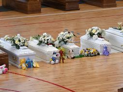 Sobre cada ataúd había un ramo de flores. Algunas personas colocaron juguetes sobre los ataúdes de los niños. EFE/C. Imbesi
