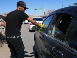 Al no contar con documentación que acredite su identidad, los extranjeros trabajan limpiando vidrios en los cruceros en Ciudad Juárez. EFE/L. Torres
