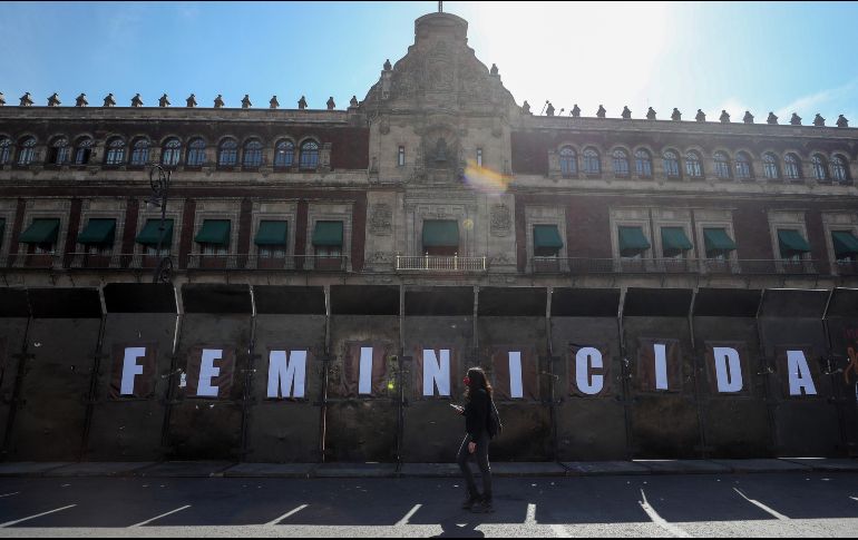 Una mujer camina afuera del Palacio Nacional, cercado por vallas, ante las marchas del 8 de marzo, Día Internacional de la Mujer. EFE / I. Esquivel