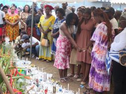 Familiares de los fallecidos y desaparecidos colocaron ofrendas en el lugar donde hallaron los cuerpos. AFP