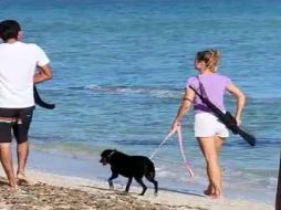 Imagen de la extranjera paseando en la playa con el arma. ESPECIAL