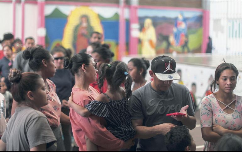 Migrantes hacen fila para recibir alimentos en las instalaciones de la organización Cafemin. EFE