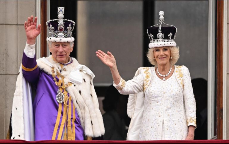 El rey Carlos III y la reina Camila saludan a los asistentes a los alrededores del Palacio de Buckingham tras la coronación. AFP / O. Scarff