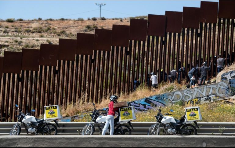 La entrega de comida no es sencilla, pero repartidores hacen el peligroso recorrido con tal de ganar unos dólares. AFP/G. Arriaga