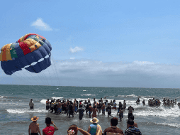 Otros turistas que permanecían en la playa quienes se unieron para tomar la cuerda y jalar para que el paracaidista aterrizara de forma segura. TWITTER / @SSPCNay