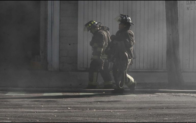 Los bomberos que acudieron a sofocar las llamas, y atribuyeron el siniestro al calentamiento excesivo de una computadora de mesa conectada a la energía eléctrica. SUN / ARCHIVO