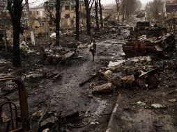 Una mujer camina entre tanques rusos destruidos en Bucha, en las afueras de Kiev, Ucrania, el domingo 3 de abril de 2022. AP / R. Abd