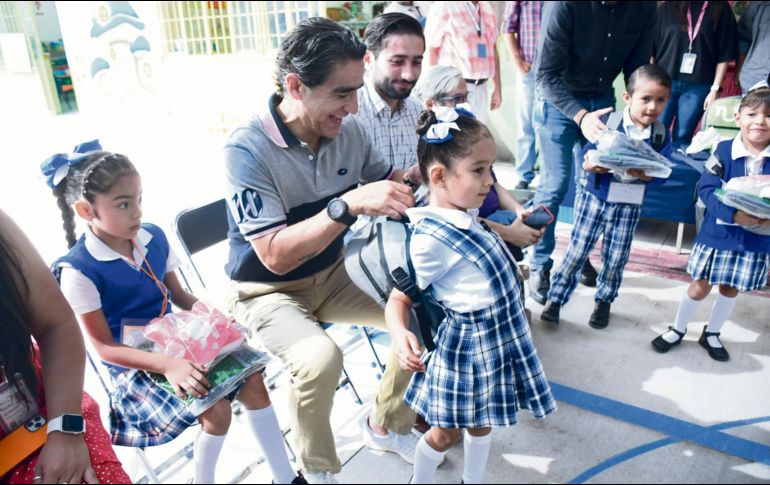 Salvador Villaseñor ayuda a una pequeña beneficiada con el programa. CORTESÍA