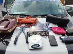 Los policías localizaron a dos hombres, quienes tenían ya en su posesión cuatro bolsas de dama, dos carteras, tres monederos, unos lentes, un celular, una báscula gramera y unas cizallas. ESPECIAL / Policía de Guadalajara