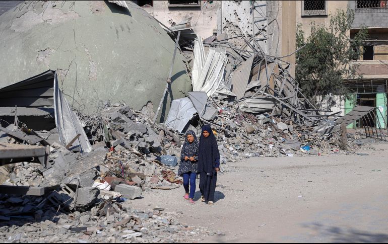 Niñas caminan al lado de edificios destruidos por bombardeos israelíes. XINHUA/R. Abdeljawad