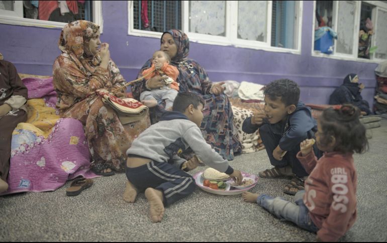 Palestinos desplazados reciben alimentos y apoyo en una escuela de la ONU, en el Sur de Gaza. EFE