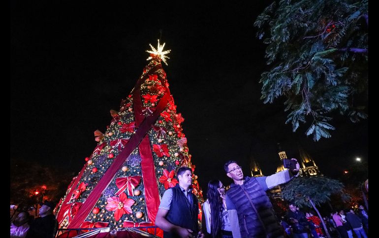 Adornado con cintas rojas y nochebuenas, el árbol fue iluminado con la catedral de fondo, seguido de un espectáculo de fuegos artificiales de todos colores, que chicos y grandes captaron con sus teléfonos celulares. EL INFORMADOR/ H. FIGUEROA