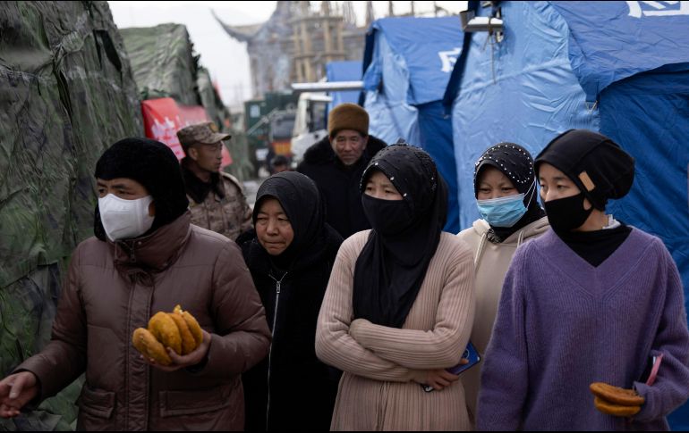 Sobrevivientes del terremoto de magnitud 6.2 que ha dejado 131 muertos reciben alimentos de ayudantes voluntarios. EFE/A. Martínez