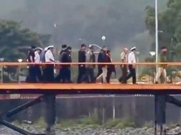 La Armada de Chile sosteniendo el cuerpo del ex mandatario mientras recorren el fuelle del Lago  Ranco tras su rescate del agua (fotografía tomada de un vídeo). ESPECIAL