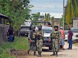 Los soldados hacen guardia e inspeccionan el área afuera de un palenque luego del ataque de hombres armados durante una pelea de gallos el 7 de enero. AFP