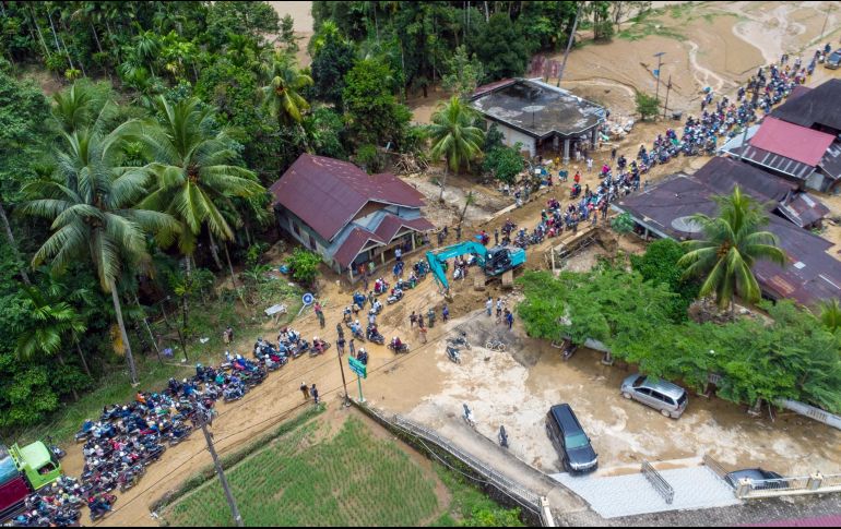 Toneladas de lodo, piedras y árboles derribados de raíz rodaron cuesta abajo en una montaña la noche de ayer viernes, hasta llegar a un río que se desbordó. AFP / M. Kayo