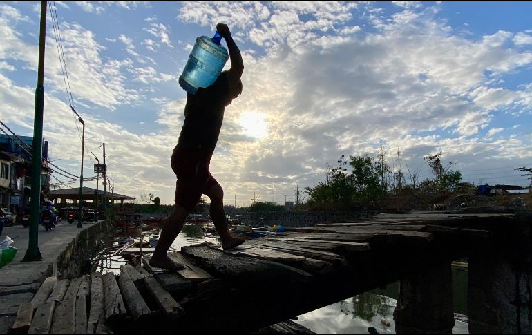 Un hombre carga un recipiente con agua en una aldea de Filipinas. La ONU estima que alrededor de 2 mil 200 millones de personas no tienen acceso a agua potable segura. EFE/F. Malasig