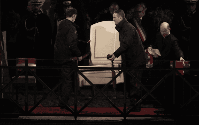 Los ujieres del Vaticano se llevan la silla del Papa Francisco antes del inicio del Vía Crucis. AP