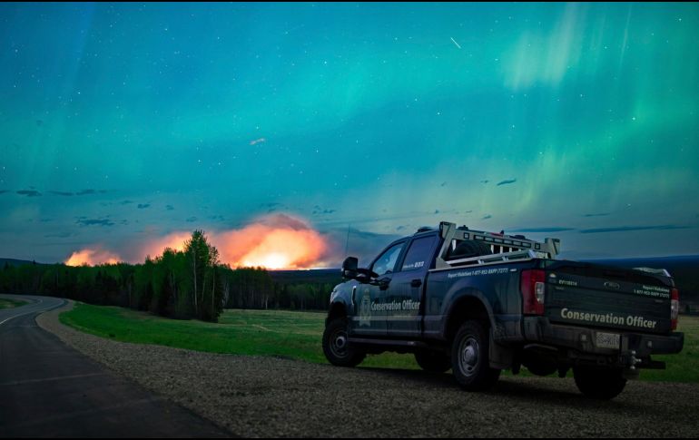 Esta imagen proporcionada por el Ministerio de Agua, Tierras y Gestión de Recursos muestra un incendio forestal, con una aurora boreal sobre el, cerca de Fort Nelson, Canadá, el sábado 11 de mayo de 2024. AP.