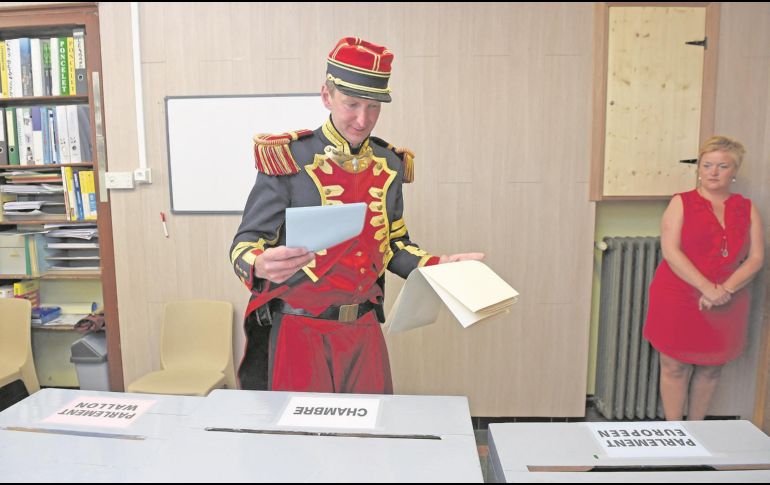 Un participante del desfile tradicional de Saint-Medard se prepara para emitir su voto. AFP/J. Thys