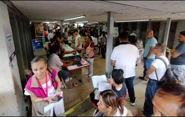 Las personas afuera de la central caminaban poco a poco siguiendo la fila, con sombreros, papeles y sombrillas se escudaban de los rayos del sol. EL INFORMADOR/ J. Padilla.