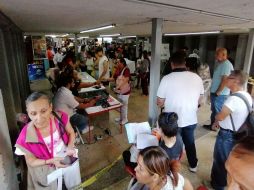 Las personas afuera de la central caminaban poco a poco siguiendo la fila, con sombreros, papeles y sombrillas se escudaban de los rayos del sol. EL INFORMADOR/ J. Padilla.