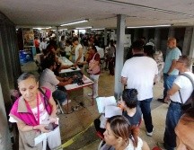 Las personas afuera de la central caminaban poco a poco siguiendo la fila, con sombreros, papeles y sombrillas se escudaban de los rayos del sol. EL INFORMADOR/ J. Padilla.