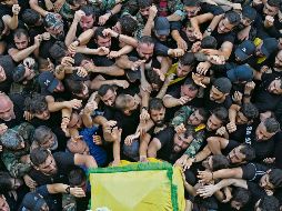 Militantes de Hezbolá se agolpan junto al féretro de uno de sus integrantes fallecidos por el ataque. EFE