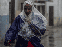 Un hombre camina entre el viento y la lluvia provocados por el huracán 