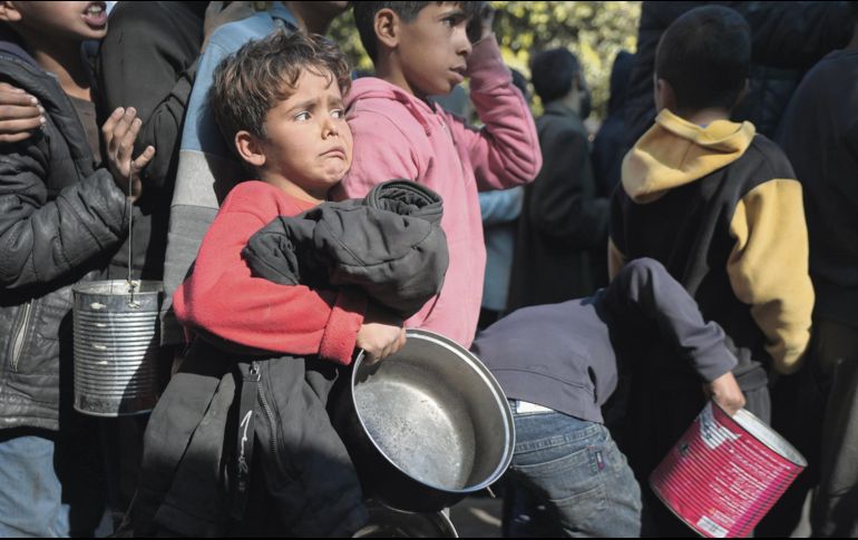 Niños palestinos hacen fila para recibir comida en Franja de Gaza. EFE