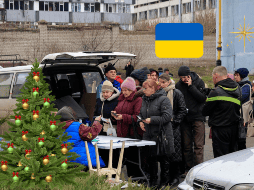 Personas reciben apoyo en un edificio de viviendas dañado por un ataque con un misil ruso en Jarkov, Ucrania. EFE/S. Kozlov